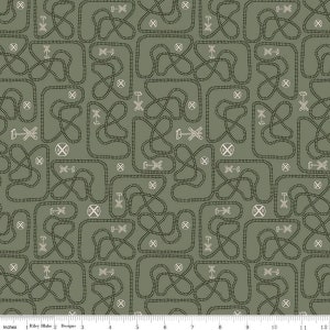 May include: A green fabric with a repeating pattern of train tracks and railroad crossing signs. The tracks are in a light brown color and the signs are white with black X's.