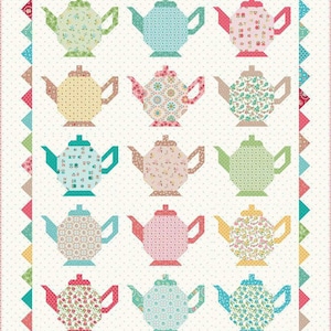 May include: A quilt with a white background and a border of colorful triangles. The center of the quilt features 15 teapots in various colors and patterns.