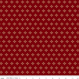 May include: A deep red fabric featuring a repeating pattern of small, light-colored four-petaled floral motifs arranged in a grid. A white ruler measuring 12 inches is visible along the bottom edge, indicating the scale of the textile design.