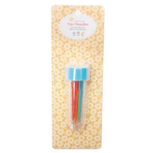 May include: A clear plastic tube with a blue lid containing a set of colorful yarn needles. The packaging is yellow with a white polka dot pattern and the text "100% Cute Yarn Needles by Lori Holt of Bee in my Bonnet".