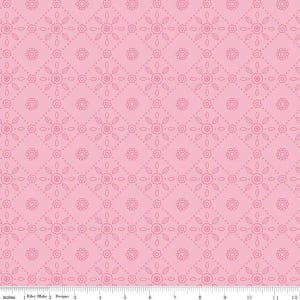 May include: Pink fabric with a repeating pattern of floral and geometric shapes. The design features small flowers and dotted lines within a diamond grid. The fabric is marked with inch measurements along the bottom edge.
