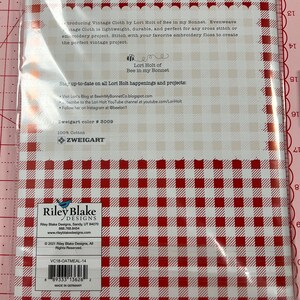 May include: A white package with red and white gingham pattern. The package contains vintage cloth by Lori Holt of Bee in my Bonnet. The package includes the text "Stay up-to-date on all Lori Holt happenings and projects: Visit Lori's Blog at BeeinMyBonnetCo.blogspot.com Subscribe to the Lori Holt YouTube channel at youtube.com/LoriHolt Follow her on Instagram at @beeloril Zweigart color # 3009 100% Cotton Zweigart" and "Riley Blake Designs Riley Blake Designs, Sandy, UT 84070 888.768.8454 www.rileyblakedesigns.com &copy; 2021 Riley Blake Designs, All Rights Reserved. VC18-OATMEAL-14 8933313626 2 MADE IN GERMANY".