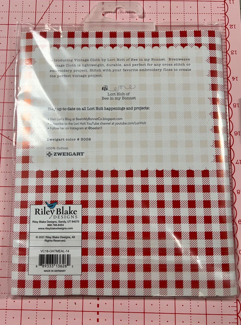 May include: A white package with red and white gingham pattern. The package contains vintage cloth by Lori Holt of Bee in my Bonnet. The package includes the text "Stay up-to-date on all Lori Holt happenings and projects: Visit Lori's Blog at BeeinMyBonnetCo.blogspot.com Subscribe to the Lori Holt YouTube channel at youtube.com/LoriHolt Follow her on Instagram at @beeloril Zweigart color # 3009 100% Cotton Zweigart" and "Riley Blake Designs Riley Blake Designs, Sandy, UT 84070 888.768.8454 www.rileyblakedesigns.com &copy; 2021 Riley Blake Designs, All Rights Reserved. VC18-OATMEAL-14 8933313626 2 MADE IN GERMANY".