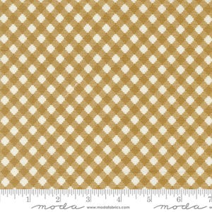 May include: Close-up of a fabric with a repeating pattern of gold and cream-colored diamonds. The fabric has a gingham or checkered design, suitable for quilting or other craft projects. The fabric is marked with a ruler along the bottom.