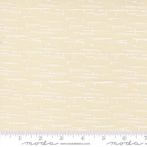May include: A light cream-colored fabric featuring a repeating pattern of thin, horizontal white dashed lines and small marks. A white measuring tape is positioned along the bottom edge, showing a scale of 7 inches for the fabric width.