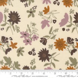 May include: A cream-colored fabric featuring a repeating floral pattern in shades of dark brown, muted orange, dusty purple, and sage green. A white ruler at the bottom shows a scale of 7 inches, with the text moda and www.modafabrics.com printed.
