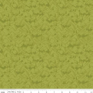 May include: A green fabric with a repeating pattern of mountains and trees. The fabric has a textured, distressed look.