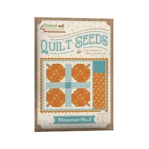 May include: A rectangular quilt pattern packet titled Baked with Love Quilt Seeds by Lori Holt of Bee in my Bonnet. The cover features a graphic of four orange pumpkin blocks separated by light blue gingham strips and a blue border, labeled Placemat No.3.