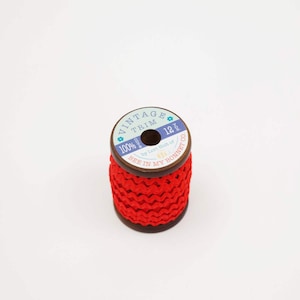 May include: A spool of red vintage trim, 12 yards long, made of 100% cotton. The spool is labeled "Vintage Trim 12 yds by Lori Holt of Bee in My Bonnet Co."