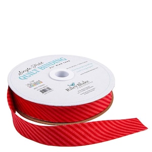 May include: A spool of red and light red striped bias tape. The tape is labeled "Single Fold Quilt Binding" and "Stripes Red Tonal". The tape is 1/8 inch wide and made of 50% spool and 100% cotton.