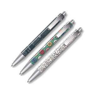 Puede incluir: Tres bolígrafos con puntas y clips plateados. Un bolígrafo es verde oscuro con texto blanco, otro tiene un patrón verde con letras coloridas y el tercero tiene un fondo blanco con letras negras.