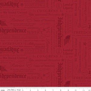 May include: Red fabric with patriotic text and imagery. The design includes words like "Independence," "Freedom," and "Justice," along with the American flag and stars. The words are in a darker shade of red.