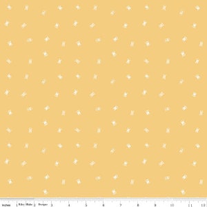 May include: Yellow fabric with a repeating pattern of white spools of thread. The fabric has a ruler along the bottom edge with the text "Inches" and "Riley Blake Designs".