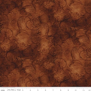 May include: A brown fabric with a swirling pattern. The fabric has a textured look and feel.
