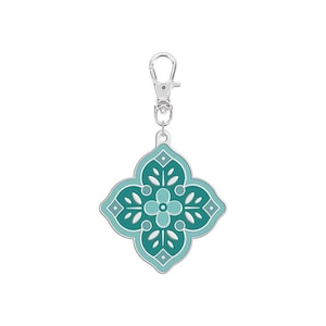 May include: A silver key chain with a teal and green patterned charm. The charm is shaped like a four-pointed star with a floral design.
