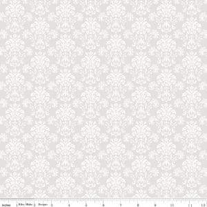 May include: A fabric with a repeating white damask pattern on a light gray background. The design features ornate floral and scroll motifs. The image includes a ruler along the bottom edge, with the text "Inches" and "Riley Blake Designs".
