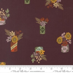 May include: A dark maroon fabric featuring a repeating pattern of floral arrangements in containers labeled coffee or tea. The print includes sunflowers, small blossoms, and foliage in shades of yellow, orange, pink, and green. A ruler is visible at the bottom.