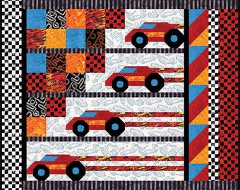 May include: A rectangular quilt featuring a central panel with four red race cars on a white background with faint car outlines. The border consists of a black and white checkered pattern, red and blue diagonal stripes, and colorful squares.