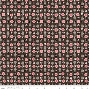 May include: A brown fabric with a repeating pattern of pink flowers, white circles with black stripes, and small green leaves.