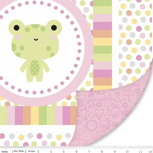 May include: A patterned fabric featuring a cartoon frog in a pink circle with polka dots. The fabric has a variety of patterns, including stripes, polka dots, and a repeating pattern of baby-themed illustrations. The color palette includes pink, green, yellow, and white.