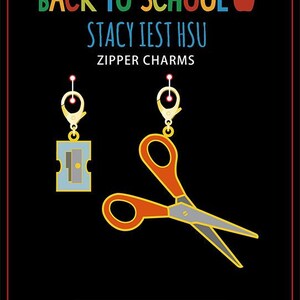 May include: Back to School zipper charms featuring a red and silver pair of scissors and a blue and silver pencil sharpener. The charms are attached to gold zipper pulls. The text "Stacy Iest Hsu" and "Zipper Charms" are printed on the black background. The text "moda fabrics + supplies" is printed in a white rectangle at the bottom of the image.