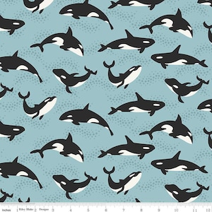 May include: A seamless pattern featuring black and white orca whales on a light blue background. The orcas are swimming in different directions and are all facing forward. The background is covered in small white dots.
