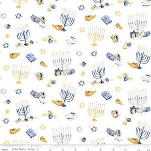 Puede incluir: Tela blanca con un patrón repetido de símbolos de Janucá. El diseño incluye menorás, dreidels, regalos, lámparas de aceite y estrellas de David en azul, amarillo y gris. El texto "Riley Blake Designs" está en la parte inferior.
