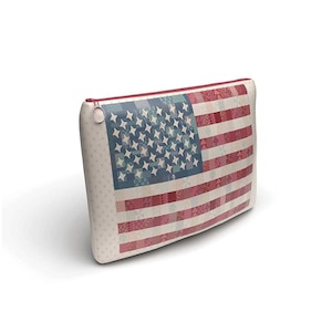 May include: A white zippered pouch with a patchwork American flag design. The flag is made up of red, white, and blue squares and stars.