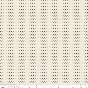 May include: Cream-colored fabric with a repeating pattern of small black polka dots. The fabric is measured in inches, with a ruler along the bottom edge. The text "Riley Blake Designs" is visible.