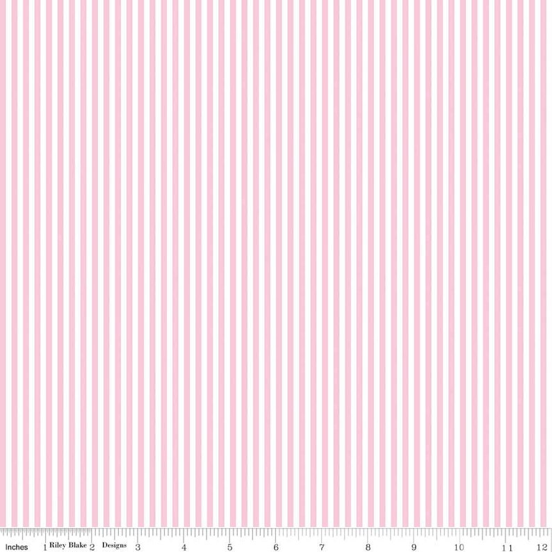 May include: A fabric featuring vertical stripes in alternating shades of pink and white. The stripes are evenly spaced and run the length of the fabric. The image includes a ruler with inch measurements along the bottom. The text "Riley Blake Designs" is visible.