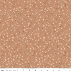 May include: A fabric with a repeating pattern of small, white floral sprigs and thin, brown stems on a solid, light brown background. The fabric is measured in inches, with the text "Riley Blake Designs" visible.