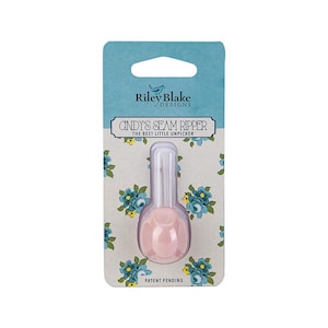 May include: Pink seam ripper with a white handle and a floral design on the packaging. The packaging says "Cindy's Seam Ripper" and "The Best Little Unpicker".