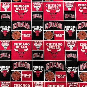 May include: Fabric featuring a repeating pattern of Chicago Bulls logos, basketballs, and the team name in red, black, and white. The design includes the team's bull logo and the word "CHICAGO" in a bold font.