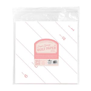 May include: A package of quilt paper with a pink label that reads "Paper Strings Quilt Paper". The paper is white with pink diagonal lines and numbers. The package is sealed in clear plastic.