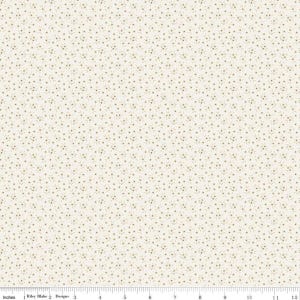 May include: A cream-colored fabric featuring a repeating pattern of tiny brown floral sprigs. A ruler at the bottom edge shows a scale of 12 inches, with the text Riley Blake Designs printed near the left side of the measurement scale.