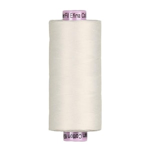May include: A spool of off-white sewing thread with a cylindrical shape. The top and bottom caps are light purple with black text that reads WonderFil Efina Cotton 60wt. The thread is wound tightly around the central core in a smooth pattern.