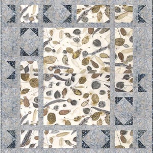 May include: A quilt with a white background and a pattern of brown leaves and branches. The quilt is framed by a border of gray and black triangles.