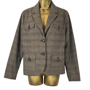 May include: A brown plaid blazer with two flap pockets and three buttons. The blazer has a notched collar and long sleeves.