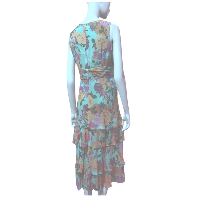 May include: A sleeveless floral print dress in shades of teal, orange, and purple. The dress features a ruched waist and tiered, ruffled skirt. The dress is displayed on a mannequin.