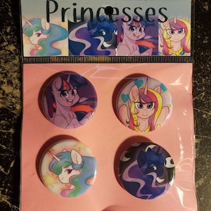 May include: Four round button pins featuring different My Little Pony characters. The characters are Twilight Sparkle, Fluttershy, Celestia, and Luna. The buttons are on a pink background with the word "Princesses" at the top.