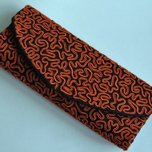 Bolso de noche clásico con forma de barrilete en seda negra con trenza bordada en naranja