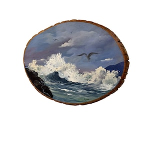May include: A circular wood slice featuring an oil painting of a turbulent ocean scene with crashing white waves against dark rocks, a cloudy blue sky, and several seagulls flying above. The artist signature M. LEE is visible in the lower right corner.
