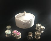 Antique German porcelain cufflink holder in the shape of a collared shirt with four sets of snap link cufflinks.