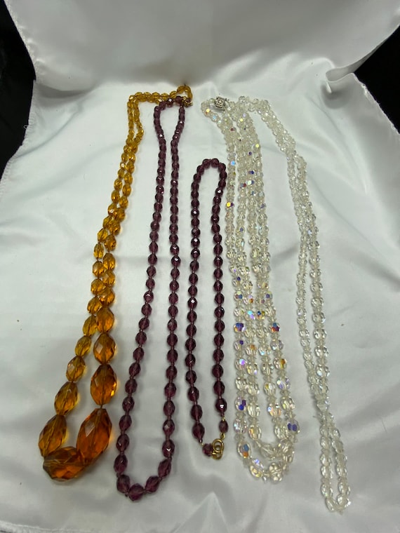 Lot of five strands of 1930s long necklaces.