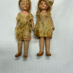 Two antique hand painted Bisque dolls in original outfits from the 1920s. There is a girl and  boy they measure 3 1/2 inches tall.