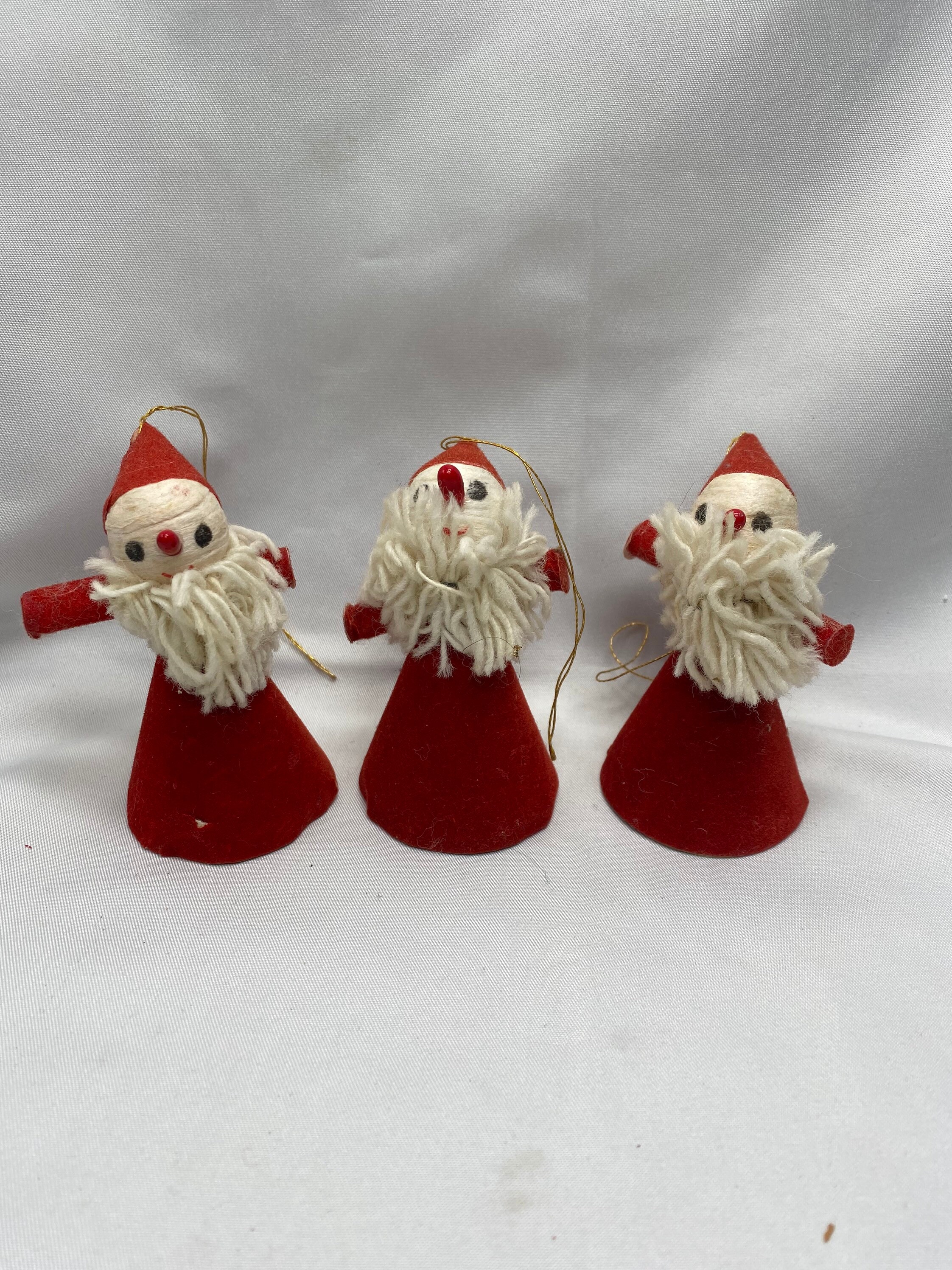 Three vintage Santa Claus Christmas tree ornaments with velvet paper outfits and mop type beards on a spun Cotton face.