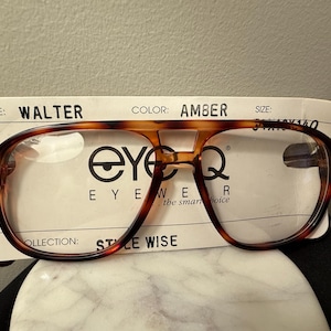 May include: Tortoise shell eyeglasses with amber lenses. The glasses are labeled "EyeQ EyeWear, the smart choice" and "Style: Walter, Color: Amber, Size: 54mm x 140".