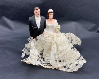 Vintage chalk ware bride and groom wedding cake topper.
