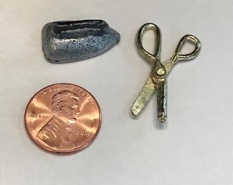 May include: A silver toy iron and a gold toy pair of scissors. A US penny is included for scale.