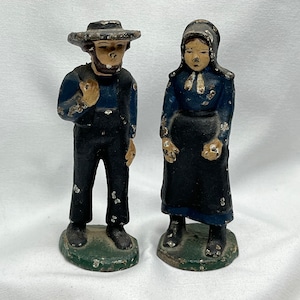 Vintage cast-iron, Amish figures, man, and a woman.
